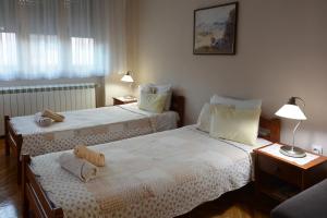 a bedroom with two beds and two tables with lamps at Sobe Gajić Sremski Karlovci in Sremski Karlovci