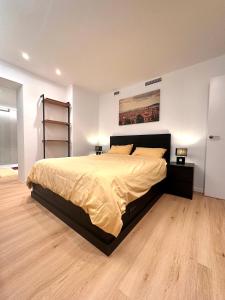 una camera con un grande letto e un pavimento in legno di Villa Bella Vista a Castelldefels
