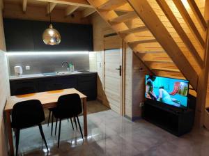 a kitchen with a table and a tv in a room at Tyrolska Chata in Świeradów-Zdrój