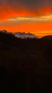 un coucher de soleil sur une chaîne de montagnes avec des nuages dans le ciel dans l'établissement Zum Bahngarten 1907, à Soprabolzano