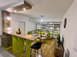 a living room with a table and green chairs at Green Apartment in Skopje