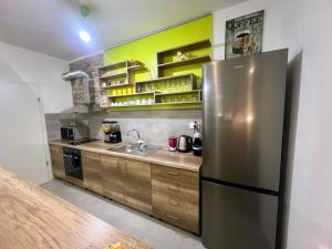 a kitchen with a stainless steel refrigerator and wooden cabinets at Green Apartment in Skopje