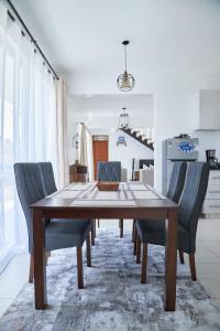 uma sala de jantar com uma mesa de madeira e cadeiras em Monarch Villas - Kilifi em Vipingo