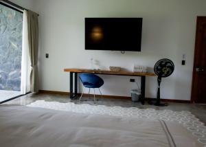 a room with a desk and a television on a wall at UKO Urbanekolodge in Armenia