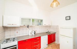 een keuken met rode kasten en witte apparaten bij Violic Apartments in Zaton