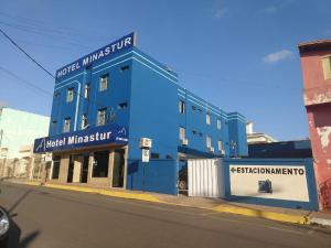 un edificio azul al lado de una calle en Hotel Minastur en Capitólio