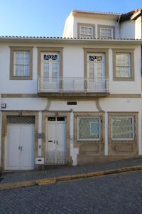 un edificio con due porte garage e un balcone di The Pine House a Peso da Régua