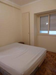 a white bed in a room with a window at Departamento 2 ambientes Centro de Mar del Plata in Mar del Plata