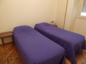 two beds in a room with purple sheets at Departamento 2 ambientes Centro de Mar del Plata in Mar del Plata