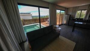 - un salon avec un canapé et une piscine dans l'établissement Vila Natur, à Sao Jorge