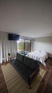 Vila Natur في ساو خورخي: غرفة نوم كبيرة مع سرير وأريكة