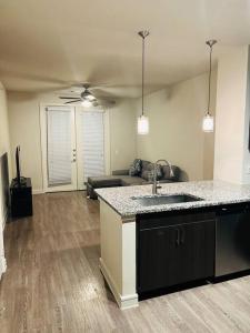 a kitchen with a sink and a living room at Home at Energy corridor in Houston