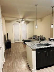 a kitchen with a sink and a living room with a couch at Home at Energy corridor in Houston