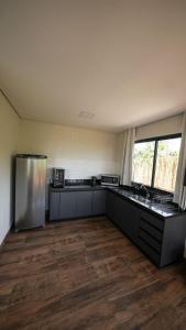 uma cozinha vazia com frigorífico e piso em madeira em Vila Natur em São Jorge