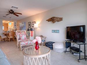 een woonkamer met een tv en een tafel bij Bay Watch 6a in Bradenton Beach