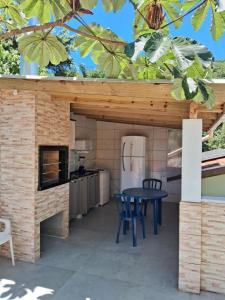 an outdoor kitchen with a table and a stove at HORTA DO TOMATE in Bombinhas