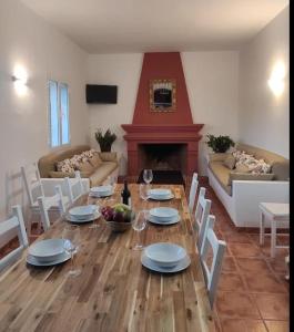 a living room with a table and chairs and a fireplace at CORTIJO RURAL FLOR DE CAZALLA in Cazalla de la Sierra