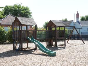 a playground with a slide and a swing set at Walkers Rest in Ganton