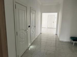 um corredor vazio com duas portas e piso em azulejo em Villa Leyla 