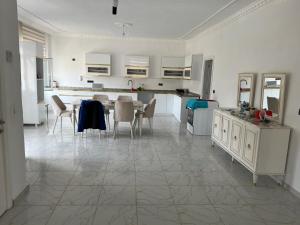 uma grande cozinha branca com uma mesa e cadeiras em Villa Leyla 