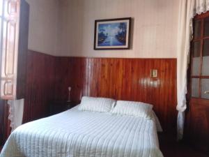um quarto com uma cama com uma cabeceira de madeira em El balcón de la Tata em San Salvador de Jujuy