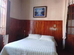 - une chambre avec un lit doté d'une tête de lit en bois dans l'établissement El balcón de la Tata, à San Salvador de Jujuy