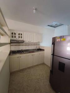 a kitchen with a stainless steel refrigerator and white cabinets at Apartamento Privado con acceso a Piscina in Santa Fe de Antioquia