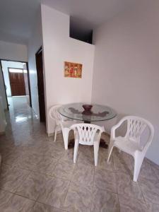 a glass table and two white chairs and a table and chairs at Apartamento Privado con acceso a Piscina in Santa Fe de Antioquia