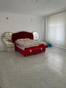 een slaapkamer met een rood bed en een dressoir bij Villa Leyla 