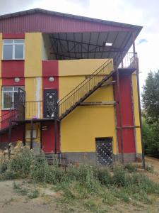 um edifício amarelo e vermelho com uma escada em Villa Leyla 