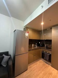 a kitchen with a stainless steel refrigerator in a room at Merkezi, havuzlu, lüx site içerisinde komförlü homeoffice in Istanbul