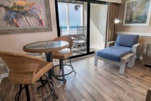 a living room with a table and chairs and the ocean at Oceanfront Escape with Private Porch 1st Floor in Pawleys Island