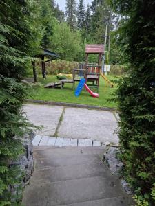 a playground with a slide and a chair in a yard at Villa Falsztyn Holiday Home in Falsztyn