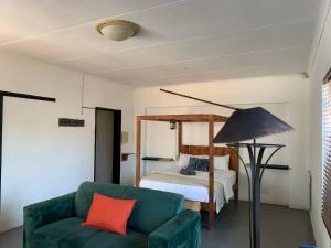 - un salon avec un canapé vert et un lit dans l'établissement TnB Guesthouse, à Middelburg