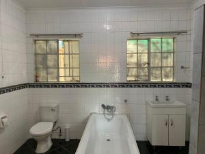 La salle de bains est pourvue d'une baignoire, de toilettes et d'un lavabo. dans l'établissement TnB Guesthouse, à Middelburg