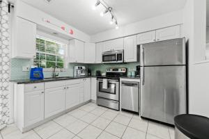 uma cozinha com armários brancos e um frigorífico de aço inoxidável em Escape to Serenity B em Holmes Beach