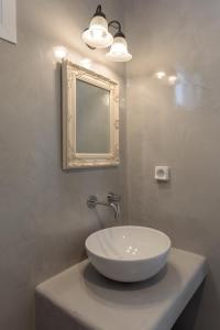 a bathroom with a white sink and a mirror at Anastasia's Garden in Archangelos