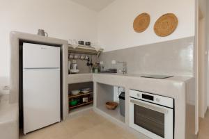 a kitchen with a counter and a white refrigerator at Anastasia's Garden in Archangelos