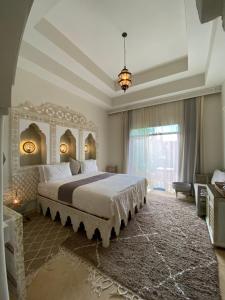 a bedroom with a large bed and a large window at La Villa Des Golfs & PinkCactus in Marrakesh