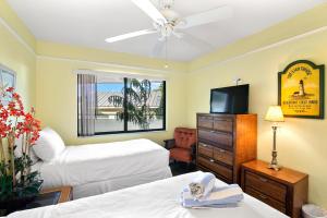 a hotel room with two beds and a flat screen tv at Bayview Condo B in Bradenton Beach