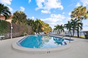 a swimming pool with palm trees in the background at Bayview Condo B in Bradenton Beach