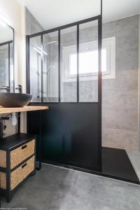 ein Bad mit einer Glasdusche und einem Waschbecken in der Unterkunft L'Orée de Nuits in Nuits-Saint-Georges