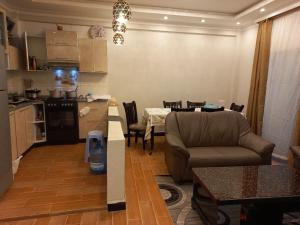 a kitchen and a living room with a couch and a table at G&19 Apartment in Addis Ababa