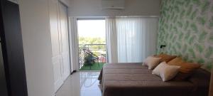 Schlafzimmer mit einem Bett und einer Tür zu einem Balkon in der Unterkunft Balcón de lecheros in Buenos Aires