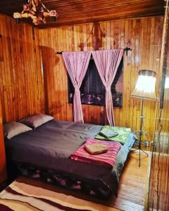 Bett in einem Holzzimmer mit Fenster in der Unterkunft Vikendica Dora Divicibare in Divčibare