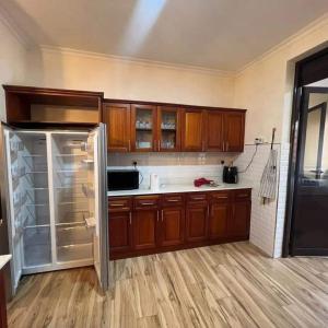 uma cozinha com armários de madeira e um frigorífico de aço inoxidável em Nalya Apartments em Kampala