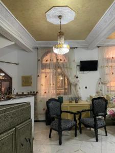 Habitación con mesa, sillas y lámpara de araña. en Riad Malak en Meknès