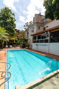 a large swimming pool in front of a house at Hotel Boutique las Rosas 5 G in Medellín