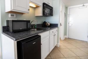 a kitchen with a sink and a microwave at Ocean Breeze Oceanfront Tower King Room 2nd Fl in Pawleys Island