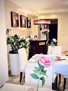 a dining room with a table with a pink rose on it at Pensjonat Rondo in Września